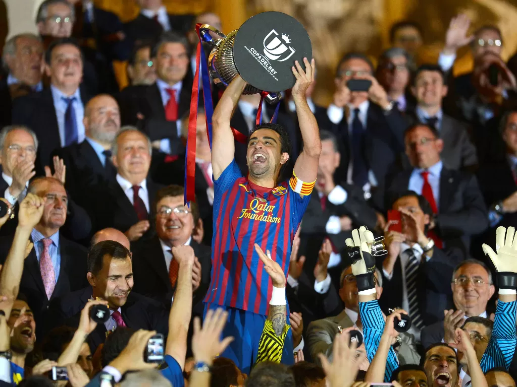 Xavi Hernandez saat mengangkat trofi Piala Raja Spanyol (REUTERS/Felix Ordonez/File Photo)