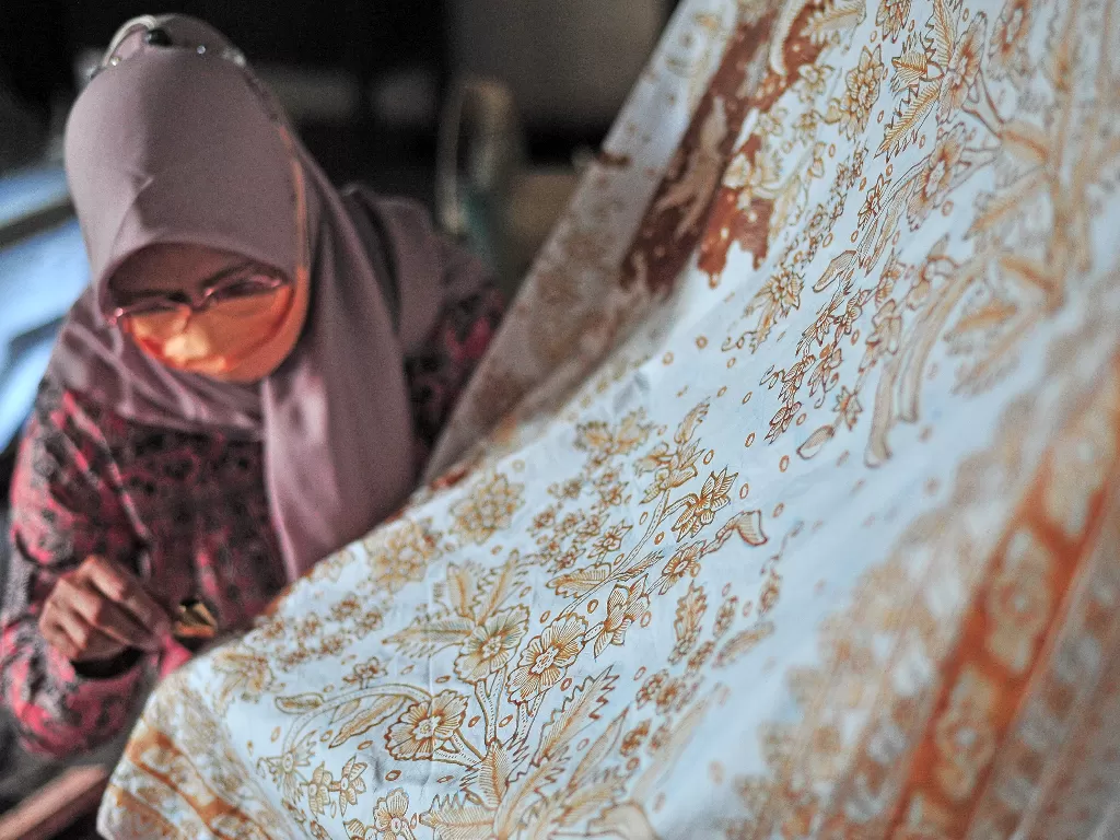 Pengrajin menyelesaikan pembuatan kain batik cap motif Bunga Serangkai di rumah produksi batik Maryana, Rengas Condong, Muara Bulian, Batanghari, Jambi, Jumat (5/11/2021). ANTARA FOTO/Wahdi Septiawan/YU