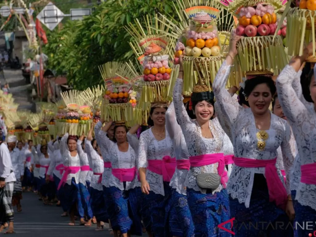 Umat Hindu menjunjung Gebogan atau sesajen berisi buah, kue, bunga dan hiasan janur dalam tradisi Mapeed saat Hari Raya Galungan di Desa Lukluk, Badung, Bali, Rabu (24/7/2019) (Foto: Antara/Nyoman Hendra Wibowo)