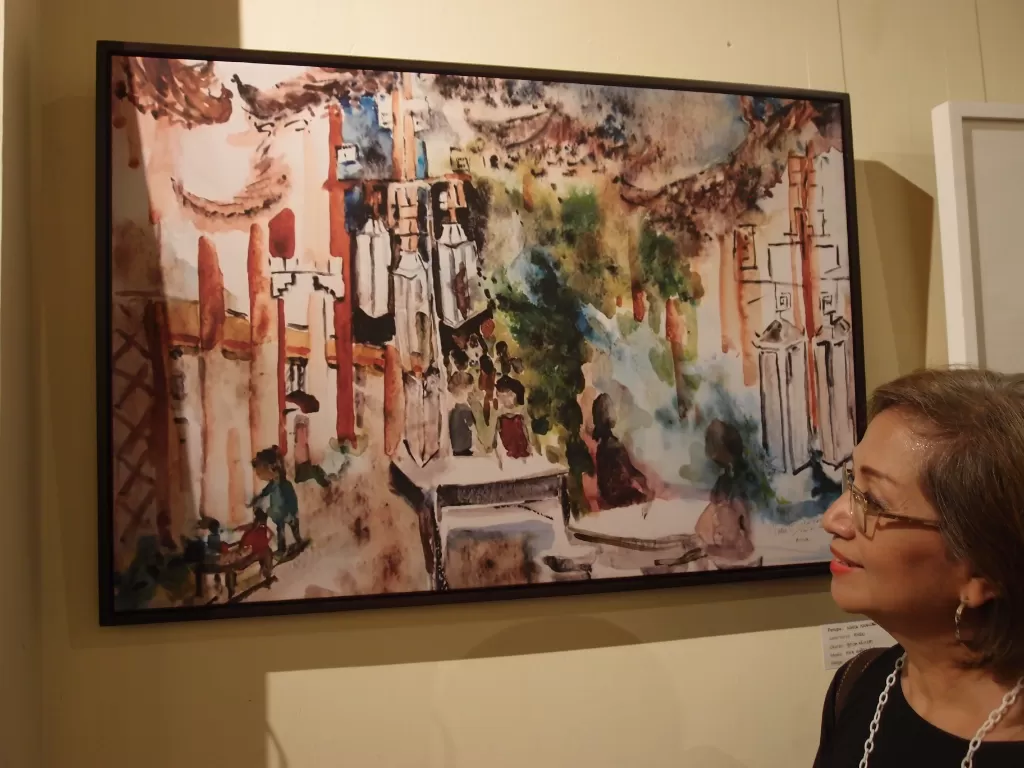 Pelukis Nadia Iskandar berpose di depan karya lukisannya berjudul 