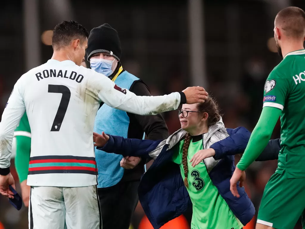 Cristiano Ronaldo memeluk penggemarnya yang masuk lapangan (Reuters/Paul Childs)