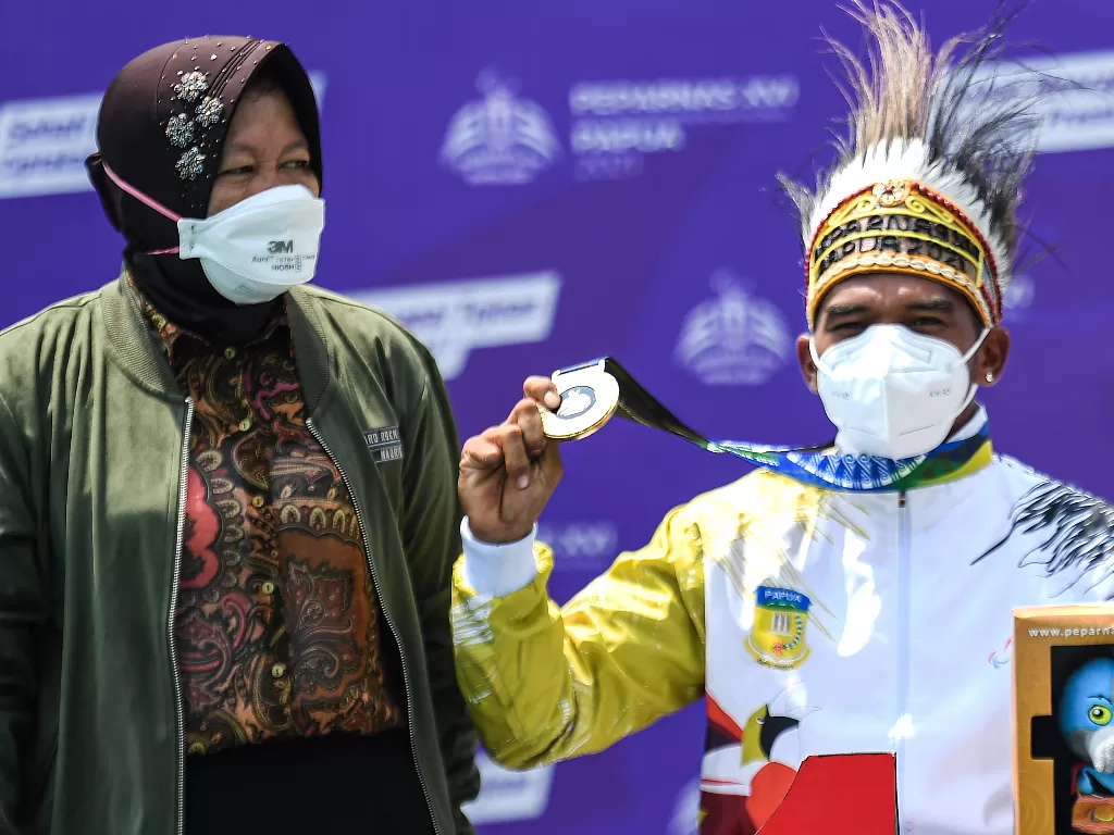  Mensos Risma bersama petenis Papua peraih medali emas tenis kursi roda tunggal putra elite Peparnas XVI Agus Fitriadi saat penyerahan medali di Sian Soor, Jayapura, Papua, Sabtu (13/11/2021). (photo/ANTARA FOTO/Indrayadi TH)