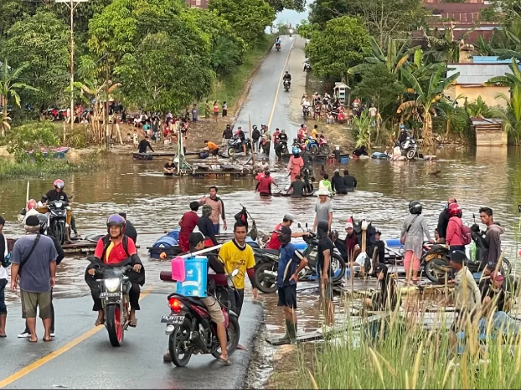 Sejumlah warga dan kendaraan memadati ruas jalan Sintang-Putussibau yang putus akibat terendam banjir di Kabupaten Sintang, Kalimantan Barat. (ANTARA FOTO/Jane Elisabeth Wuysang)