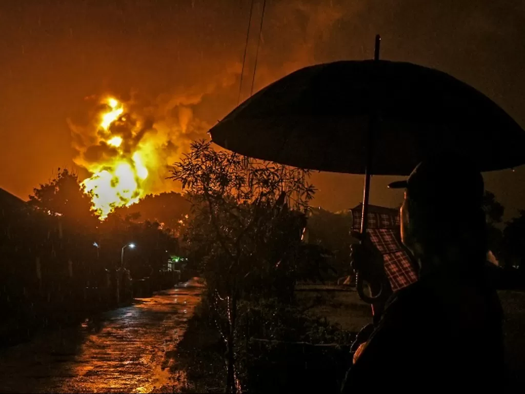 Warga menonton kobaran api yang terlihat di Kilang Pertamina Internasional (KPI) RU IV Cilacap, Jawa Tengah. (ANTARA FOTO/Idhad Zakaria)