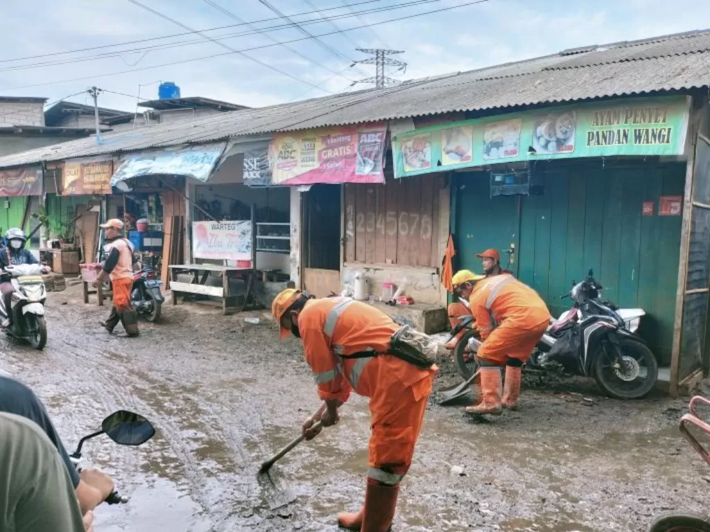 Petugas PPSU tengah membersihkan lumpur pasca banjir terjadi di kawasan Mampang, Jakarta Selatan, Sabtu (13/11/2021). (ANTARA/Walda)