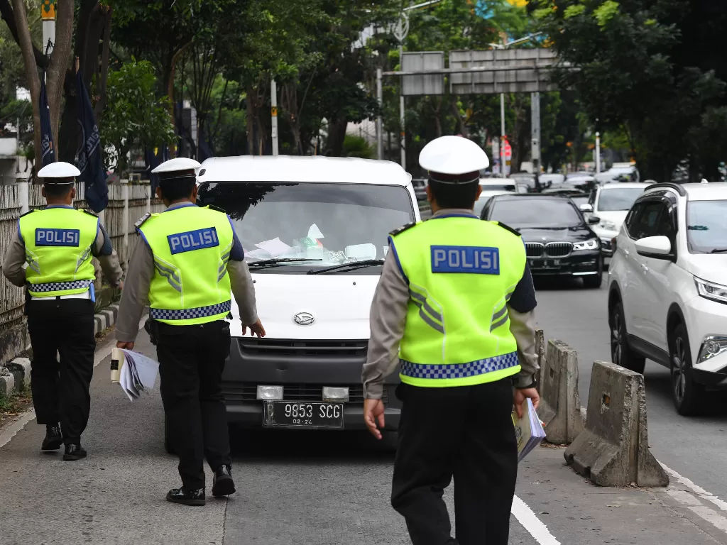 Petugas kepolisian memberhentikan kendaraan yang memasuki jalur khusus Transjakarta saat Operasi Zebra Jaya 2021. (ANTARA FOTO/Hafidz Mubarak A/foc)