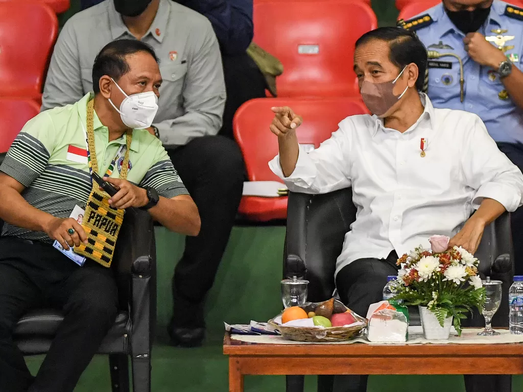 Presiden Joko Widodo (kanan) berbincang dengan Menpora Zainudin Amali (kiri) saat menyaksikan pertandingan final bulu tangkis Peparnas Papua di Gor Cendrawasih, Jayapura, Papua, Sabtu (13/11/2021). ANTARA FOTO/Raisan Al Farisi/nym.