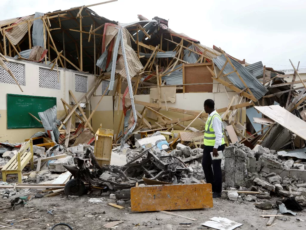 Seorang polisi memeriksa puing-puing ruang kelas yang hancur akibat serangan bom mobil di Mogadishu, Somalia. (REUTERS/Feisal Omar)