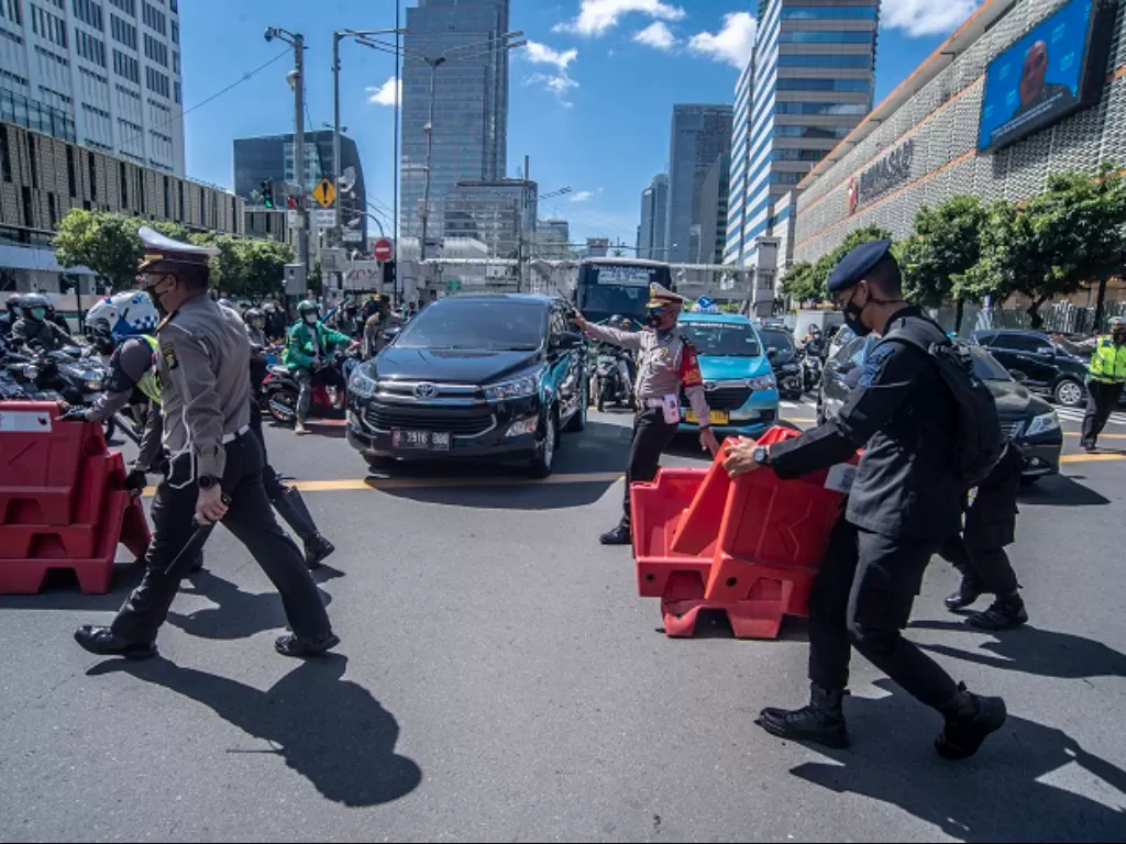 Petugas kepolisian melakukan penyekatan jalan untuk mengantisipasi membludaknya massa reuni 212 di Sarinah Thamrin, Jakarta. (ANTARA FOTO/Muhammad Adimaja)