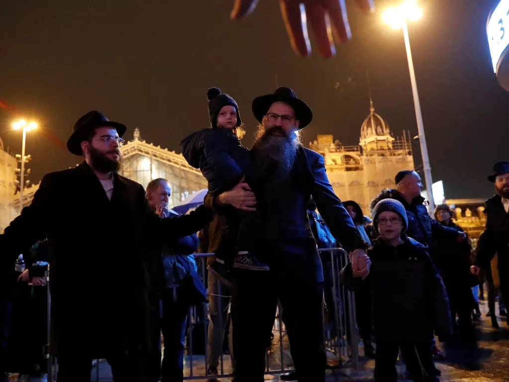Anggota komunitas Yahudi Hongaria berkumpul untuk merayakan Hanukkah dan menyalakan lilin pertama di menorah di pusat kota Budapest, Hongaria (REUTERS/Bernadett Szabo)