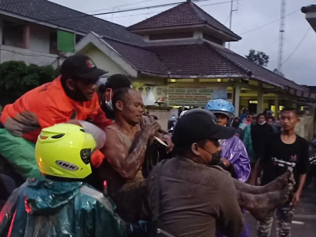 Petugas mengevakuasi warga terdampak erupsi Gunung Semeru di Sumberwuluh, Lumajang, Jawa Timur, Sabtu (4/12/2021).  (photo/ANTARA FOTO/HO/Muhammad Sidkin Ali)