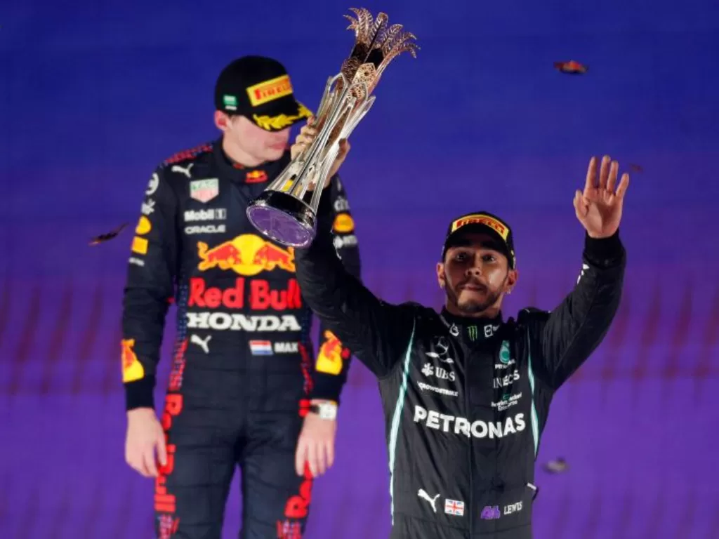 Pebalap Mercedes Lewis Hamilton merayakan kemenangan bersama trofi di podium setelah menjuarai balapan Grand Prix F1 Arab Saudi di Sirkuit Corniche Jeddah (REUTERS/HAMAD I MOHAMMED) 