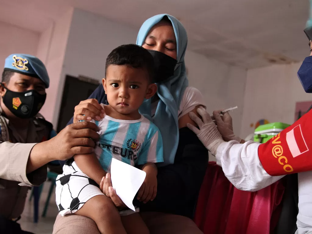 Personel Polsek Kemaraya membantu warga saat menerima suntikan vaksin Covid-19 di Polsek Kemaraya, Kendari, Sulawesi Tenggara, Kamis (2/12/2021). (ANTARA FOTO/Jojon/hp)
