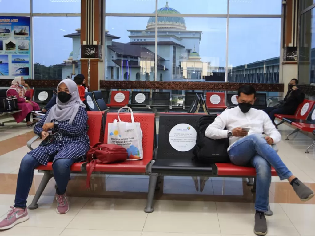 Sejumlah calon penumpang duduk di ruang tunggu keberangkatan Bandara internasional Sultan Iskandar Muda. (ANTARA FOTO/Syifa Yulinnas)