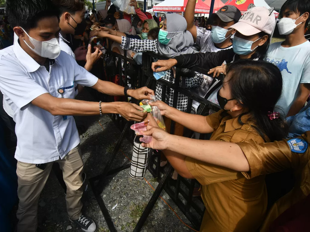 Warga berebut untuk membeli minyak goreng pada gelaran pasar murah jelang Natal dan Tahun Baru 2022 di Palu, Sulawesi Tengah, Selasa (14/12/2021). (ANTARA FOTO/Mohamad Hamzah/hp)