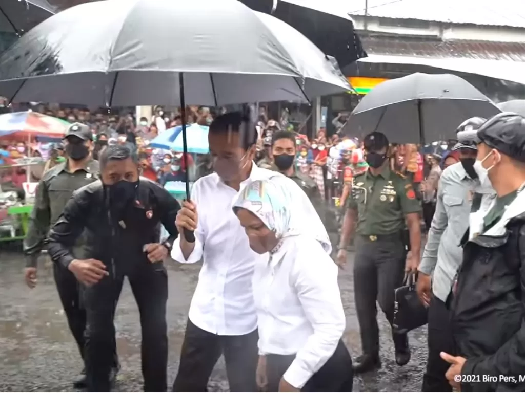 Jokowi payungi Iriana Jokowi saat berkunjung ke Pasar Kretek Wonosobo. (Youtube/Sekretariat Presiden)