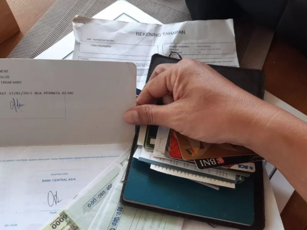 Buku bank dan ATM milik Az, yang diduga menipu belasan orang warga Tanjungpinang dalam bisnis forex. (photo/ANTARA/Nikolas Panama)