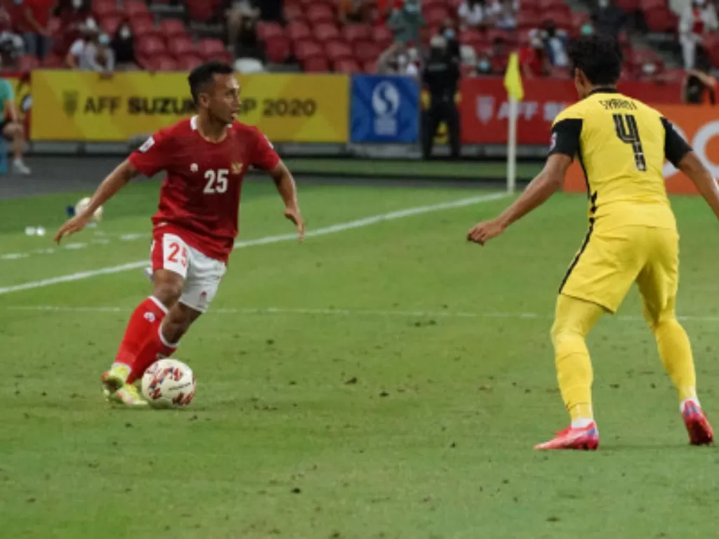 Irfan Jaya(kiri) berusaha melewati pemain Malaysia Muhammad Syami (kanan) dalam pertandingan grup B Piala AFF 2020 (ANTARA FOTO/Humas PSSI)