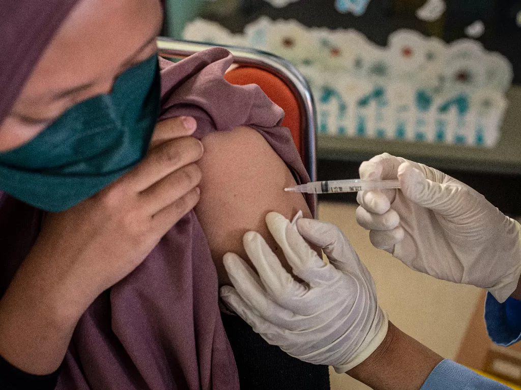 Tenaga kesehatan menyuntikkan vaksin COVID-19 kepada warga di Jakarta, Jumat (17/12/2021). (ANTARA FOTO/Aprillio Akbar)