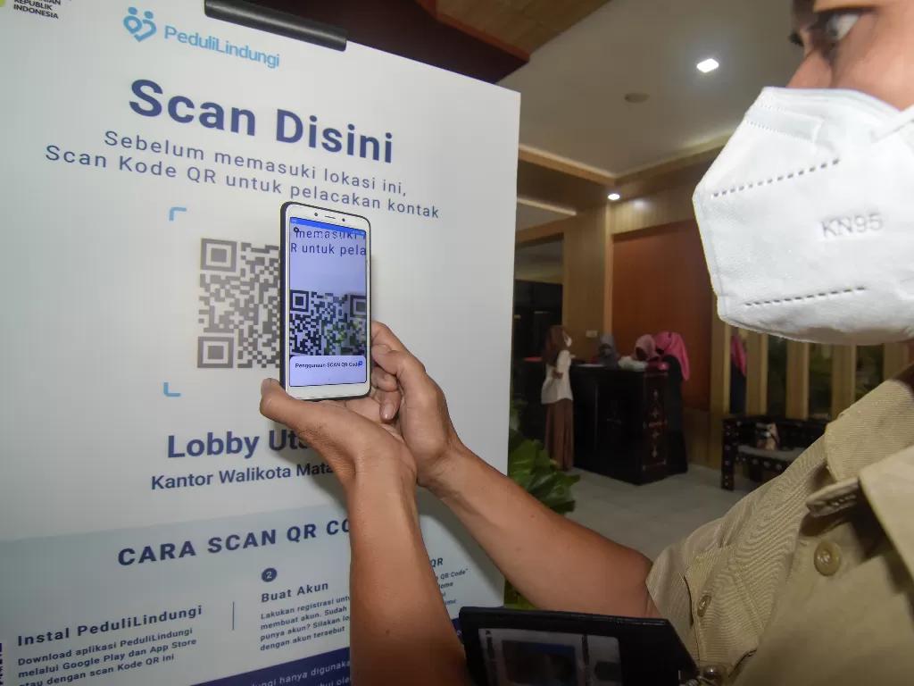 Seorang ASN Pemerintah Kota Mataram memindai QR Code dengan aplikasi PeduliLindungi. (Foto: ANTARA/Ahmad Subaidi)