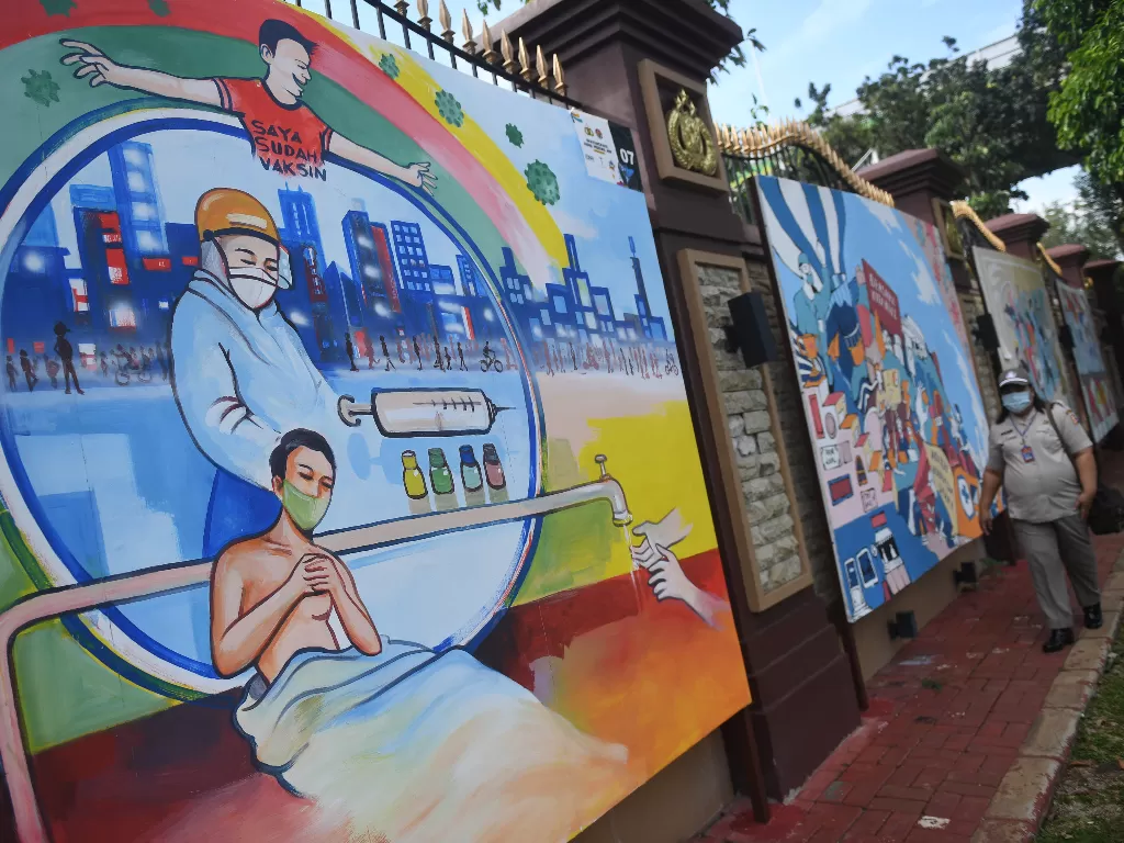 Warga melintas di dekat mural bertema COVID-19 di Jakarta. Gubernur Anies Baswedan menyebutkan kasus covid-19 terkendali namun ada kenaikan kasus. (ANTARA FOTO/Akbar Nugroho Gumay).