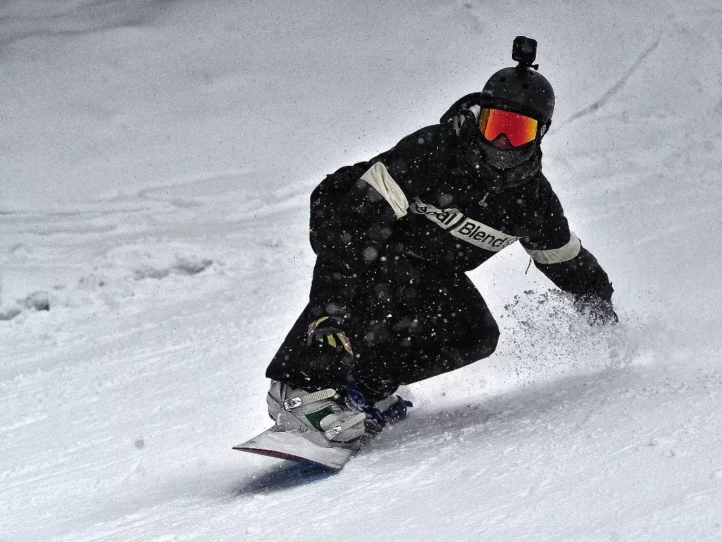 Seseorang sedang snowboarding di daerah bersalju. (photo/Pexels/Fede Roveda)