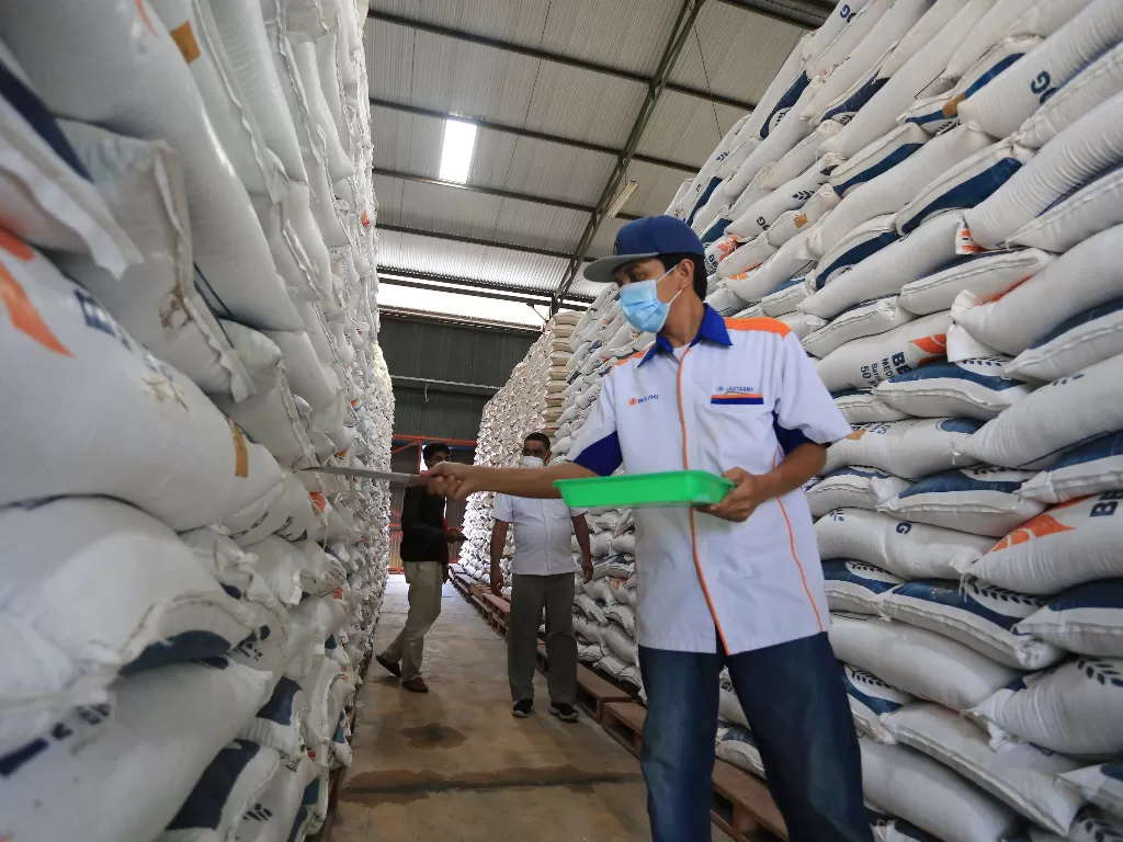 Pekerja memeriksa stok beras di gudang Bulog Sub divre Indramayu, Jawa Barat, Kamis (9/12/2021). (ANTARA FOTO/Dedhez Anggara)