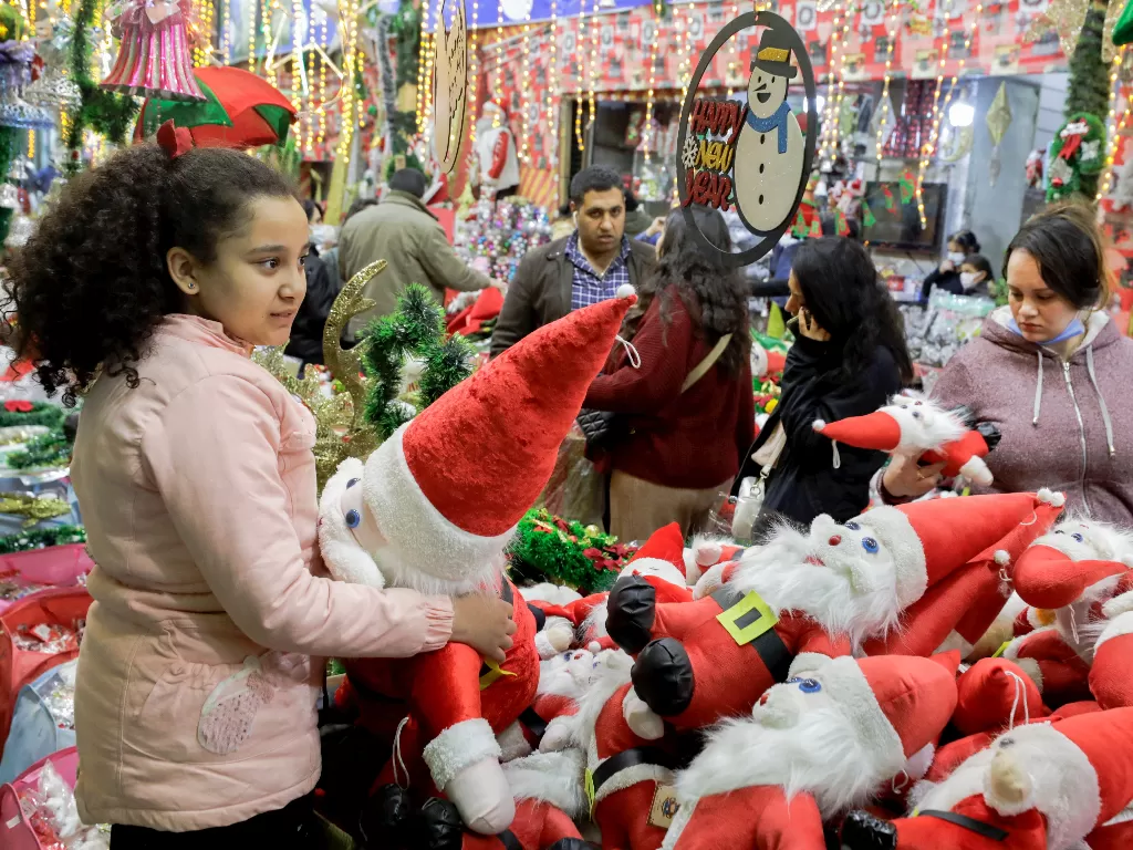 Sejumlah warga berbelanja kebutuhan Natal di ibu kota Kairo, Mesir, Jumat (24/12/2021) (REUTERS/Mohamed Abd El Ghany)