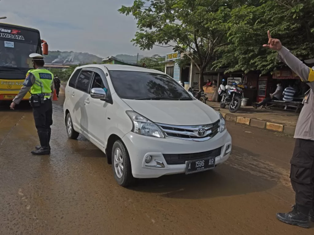 Satlantas Polres Cilegon memerintahkan putar arah kepada pengemudi kendaraan roda empat saat uji coba penerapan sistem gage menuju Pantai Anyer. (ANTARA FOTO/Asep Fathulrahman)
