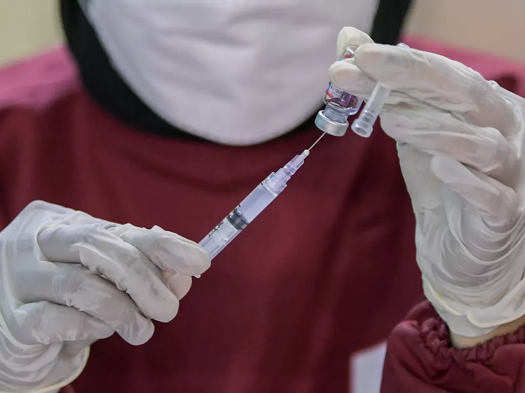 Petugas kesehatan bersiap menyuntikkan vaksin COVID-19 kepada warga di Gelanggang Remaja Makassar, Jakarta. (ANTARA FOTO/Galih Pradipta)