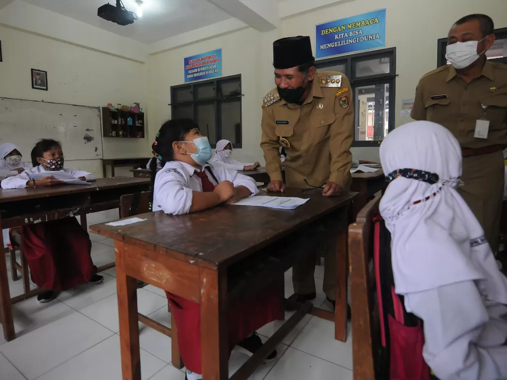 Bupati Boyolali M Said Hidayat (tengah) berbincang dengan seorang siswa sekolah dasar yang akan menerima vaksinasi COVID-19 di SD Negeri 1 Boyolali, Jawa Tengah, Senin (20/12/2021). (ANTARA FOTO/Aloysius Jarot Nugroho)