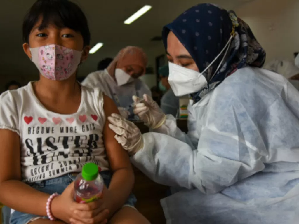 Petugas kesehatan menyuntikkan vaksin COVID-19 jenis Sinovac pada seorang anak saat vaksinasi massal anak usia 6-11 tahun di Rumah Sakit Universitas Sumatera Utara (USU), Kota Medan, Sumatera Utara, Kamis (30/12/2021). (Foto: Antara/Fransisco Carolio)