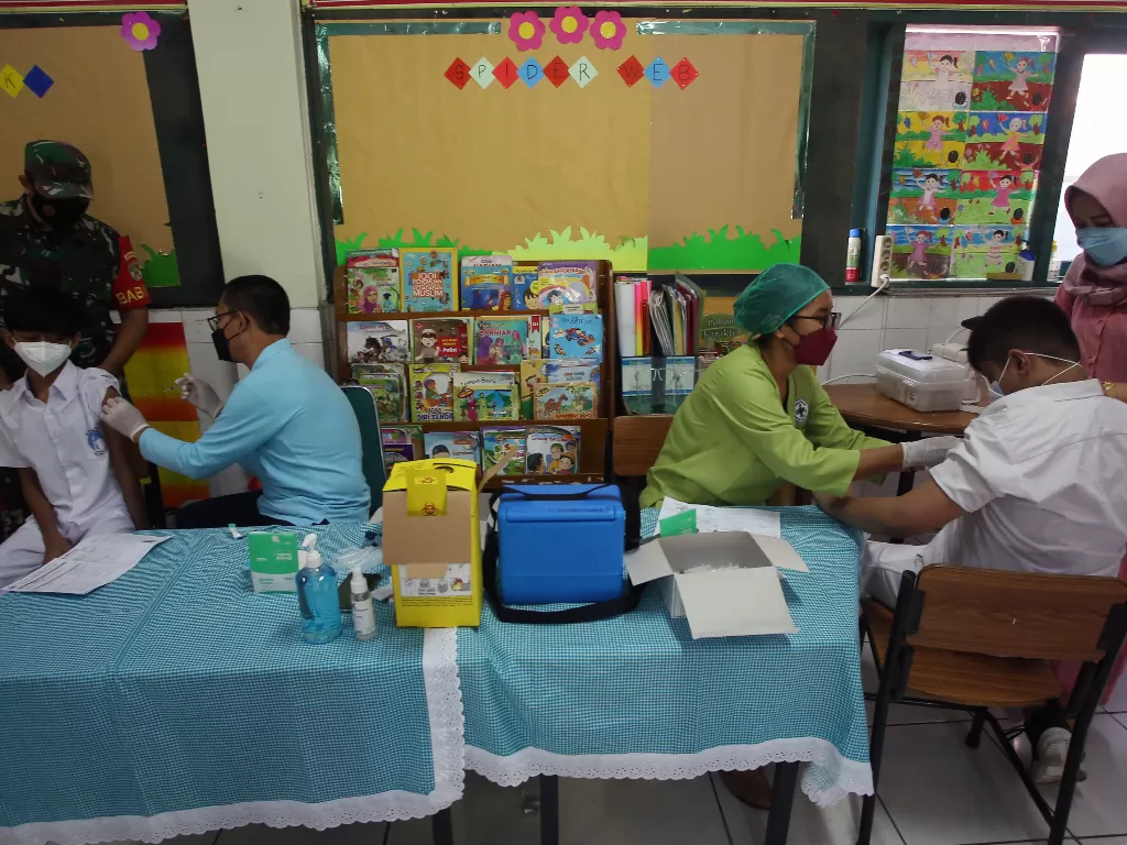 Tenaga kesehatan menyuntikkan vaksin COVID-19 ke murid sekolah dasar (SD) di SDI Al Azhar 5 Kebayoran Lama, Jakarta, Senin (3/1/2022). (ANTARA FOTO/Muhammad Iqbal)