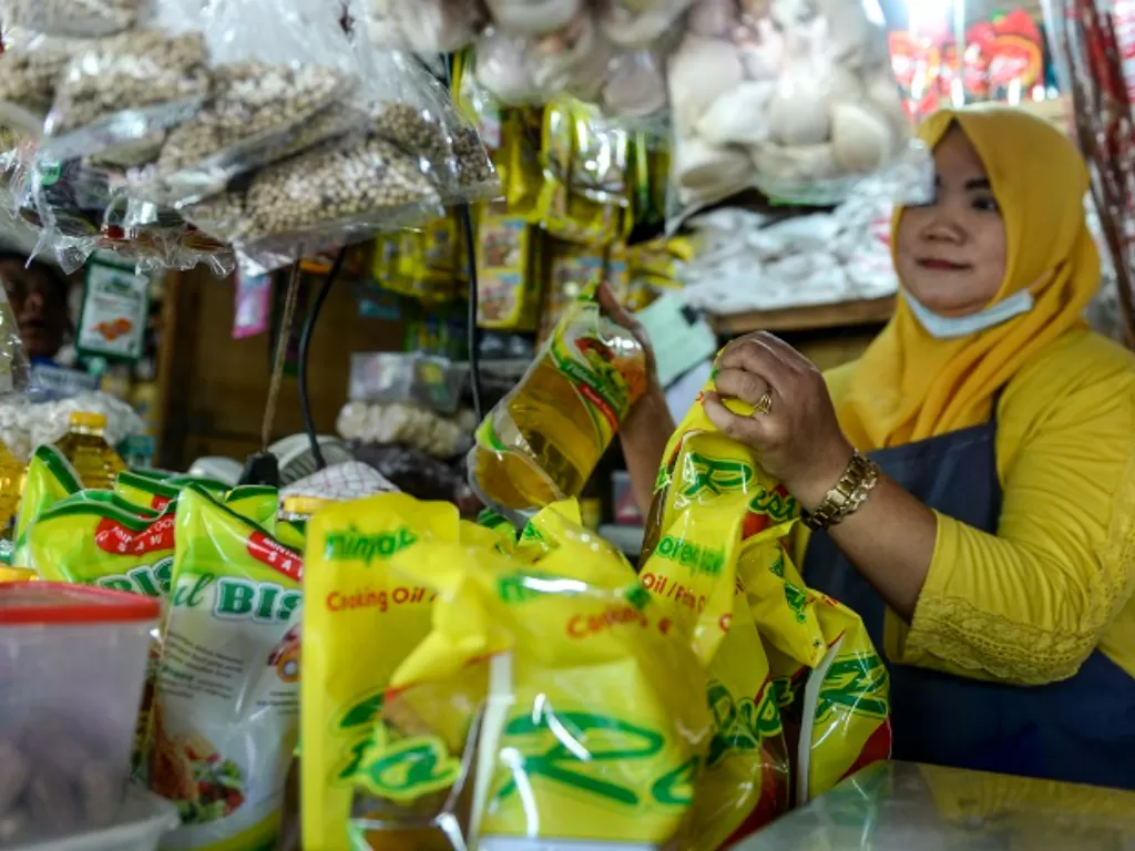 Seorang pedagang menunjukkan minyak goreng kemasan dagangannya di Pasar Malaka, Rorotan, Jakarta. (ANTARA FOTO/M Risyal Hidayat)