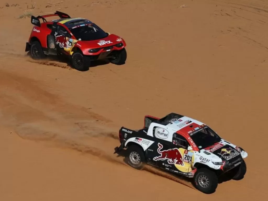 Pebalap tim Toyota Gazoo Racing Nasser Al-Attiyah dan co-driver Matthieu Baumel beradu kecepatan dengan pebalap tim BRX Sebastien Loeb dan co-driver Fabian Lurquin di etape 5 Reli Dakar di Riyadh, Arab Saudi. (6/1/2022) (ANTARA/REUTERS/HAMAD I MOHAMMED)