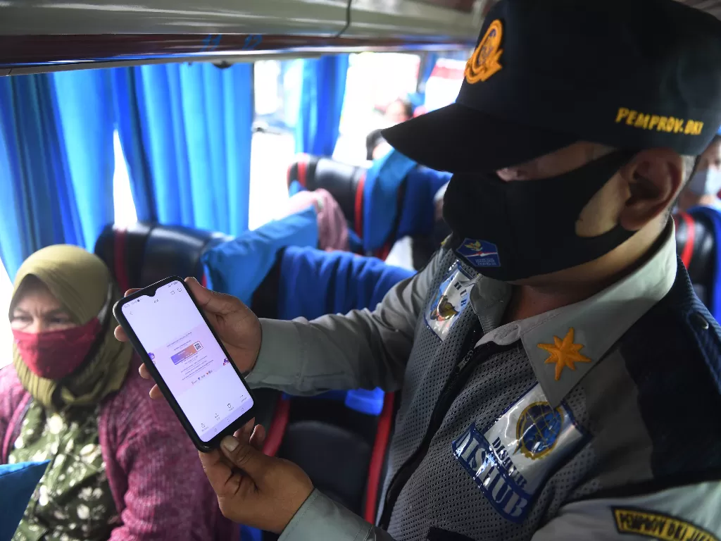 Petugas memeriksa serifikat vaksinasi penumpang bus AKAP di Terminal Kampung Rambutan, Jakarta, Kamis (6/1/2022). (ANTARA FOTO/Akbar Nugroho Gumay)