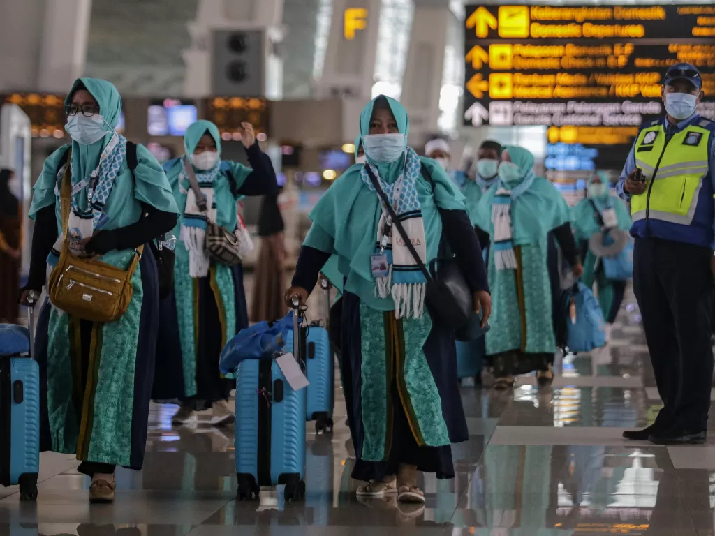 Sejumlah calon jamaah umrah berjalan di Terminal 3 Bandara Internasional Soekarno-Hatta, Tangerang, Banten, Sabtu (8/1/2022). (ANTARA FOTO/Fauzan)