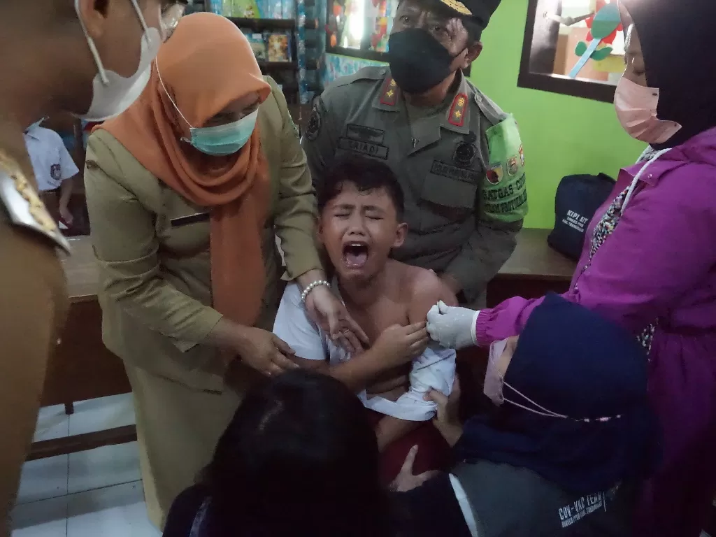 Seorang siswa peserta vaksinasi anak menangis saat hendak disuntik vaksinasi COVID-19 di SDN 2 Surodakan, Trenggalek, Jawa Timur. (ANTARA FOTO/Destyan Sujarwoko)