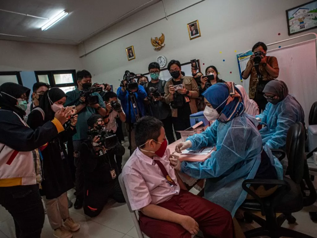 Tenaga kesehatan (kanan) menyuntikkan vaksin COVID-19 kepada pelajar di SDN Cempaka Putih Timur 03, Jakarta. (ANTARA FOTO/Aprillio Akbar)