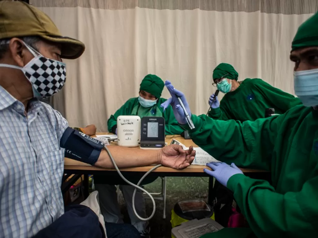 Nakes melakukan pemeriksaan kesehatan kepada warga calon penerima vaksin booster di Puskesmas Kecamatan Kramat Jati. (ANTARA FOTO/Aprillio Akbar)