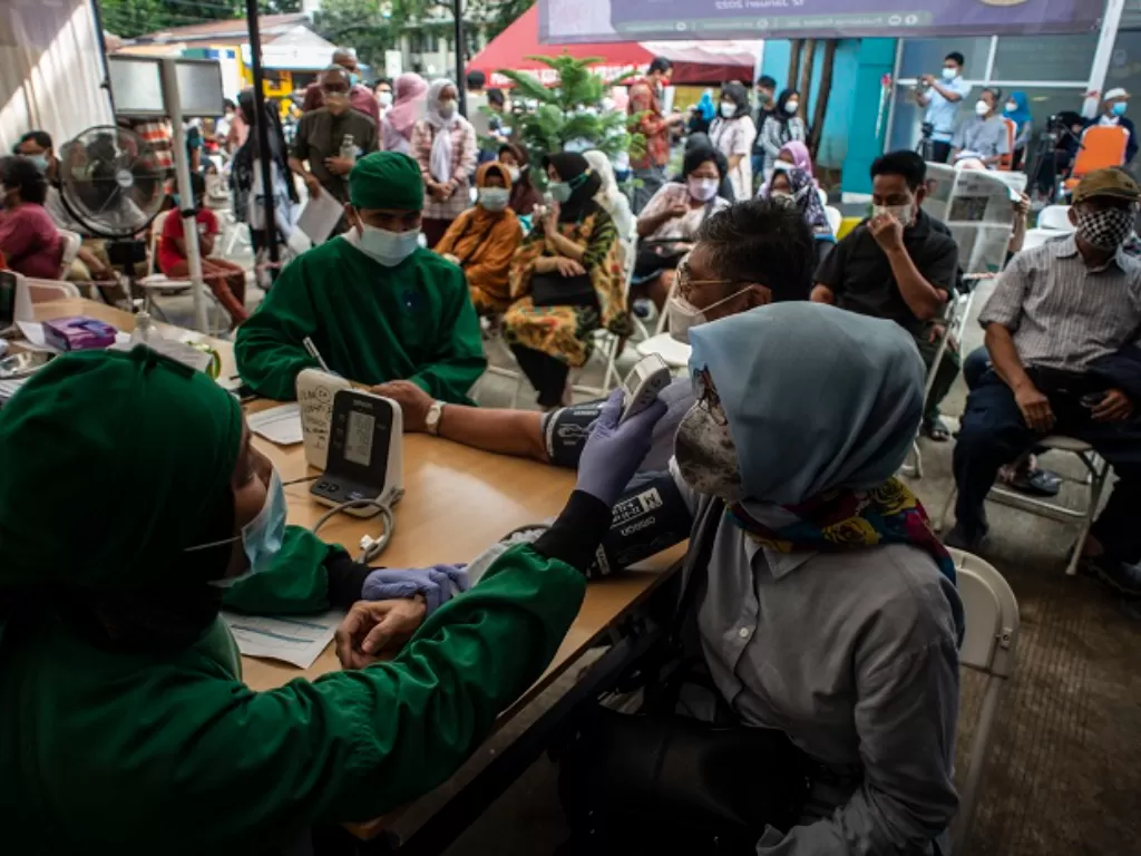 Nakes melakukan pemeriksaan kesehatan kepada calon penerima vaksin booster Covid-19 di Puskesmas Kecamatan Kramat Jati, Jakarta Timur. (ANTARA FOTO/Aprillio Akbar)