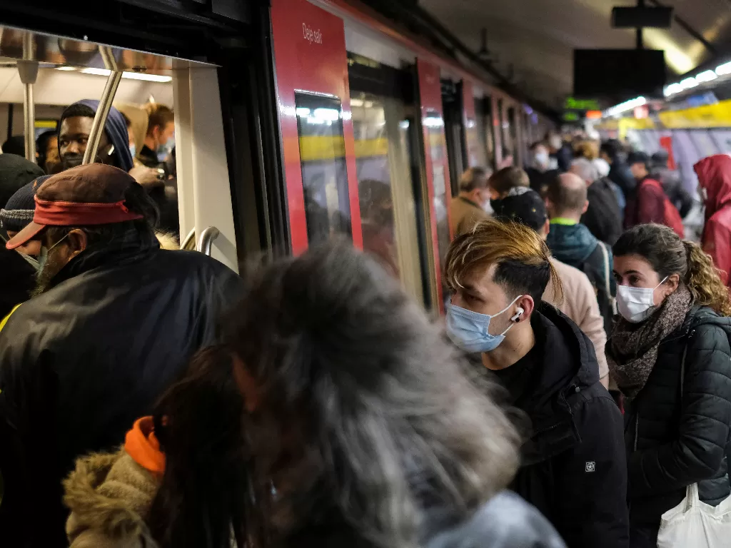 Para komuter menunggu kereta di stasiun kereta bawah tanah, di tengah merebaknya penyakit virus corona (COVID-19) dan setelah Omicron merebak di Eropa. (REUTERS/Nacho Doce)