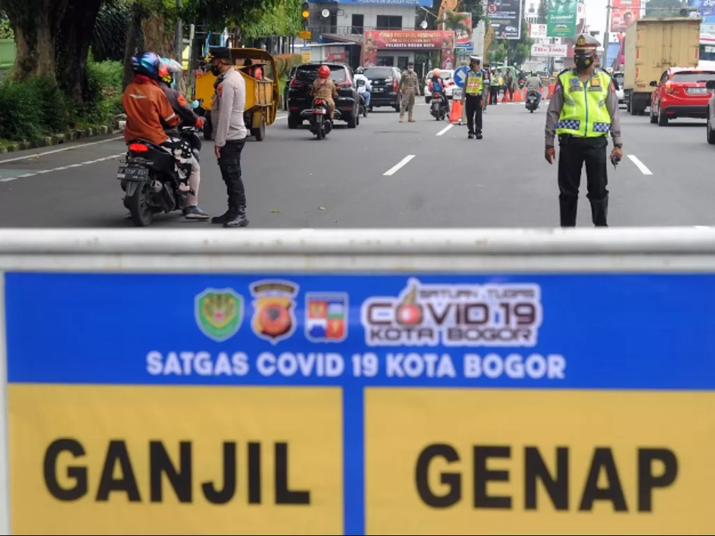 Anggota Polresta Bogor Kota mengatur arus lalu lintas saat pemberlakuan sistem gage di Simpang Baranangsiang, Kota Bogor. (ANTARA FOTO/Arif firmansyah)