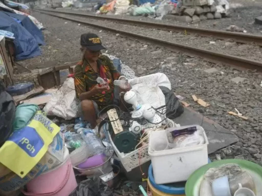  Pemulung memilah barang di samping rel kereta api di Tanah Tinggi, Johar Baru, Jakarta, Jumat (1/1/2021). (Foto: ANTARA/Akbar Nugroho Gumay)