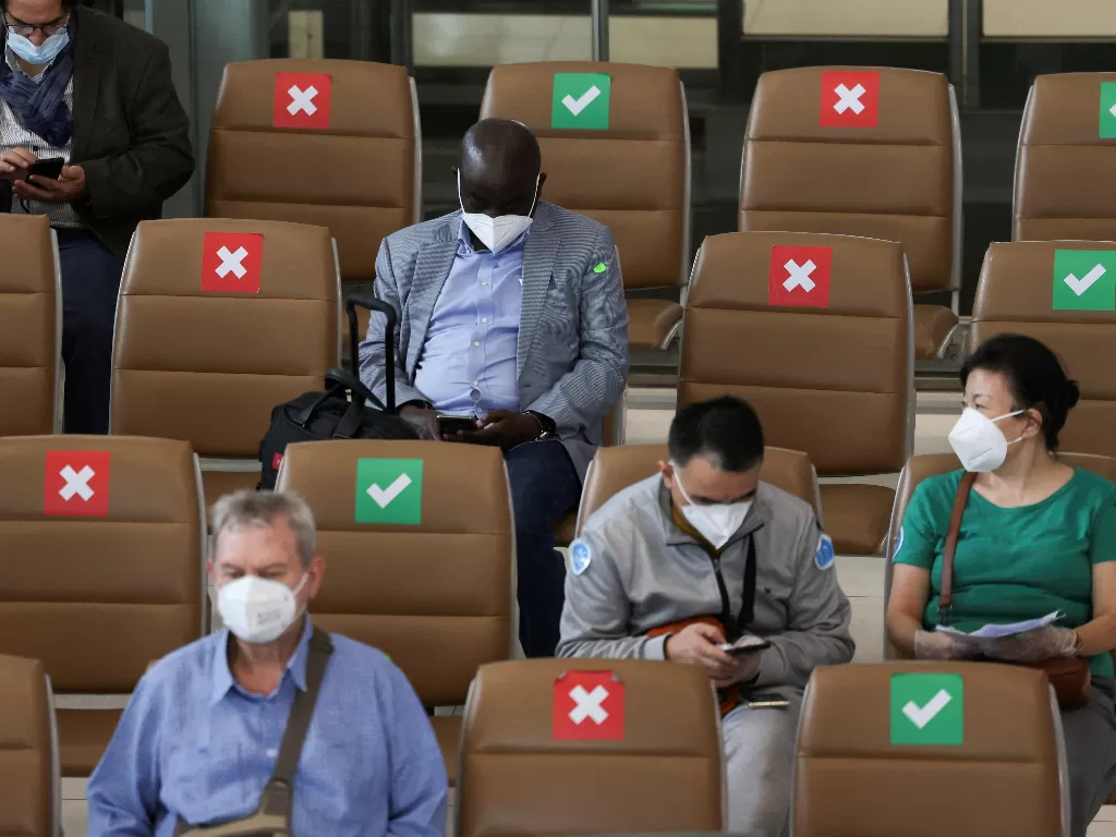 Turis asing menunggu penerbangan mereka di Bandara Suvarnabhumi Bangkok saat Thailand melarang masuk dari 8 negara Afrika karena varian baru virus corona Omicron. (REUTERS/Chalinee Thirasupa)