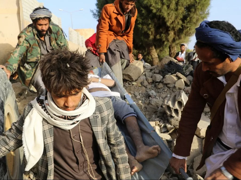 Sejumlah warga membantu korban serangan udara oleh Koalisi Arab Saudi ke Yaman. (REUTERS/Naif Rahma)