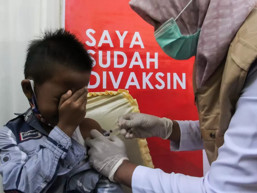 Petugas medis menyuntikkan vaksin COVID-19 jenis Sinovac kepada seorang anak di SD Negeri 1 Lhokseumawe, Aceh, Kamis (20/1/2022). (ANTARA/Rahmad)