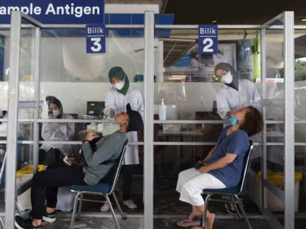 Petugas melakukan swab test antigen kepada calon penumpang kereta api di Stasiun Gambir, Jakarta, Minggu (2/1/2022). (ANTARA FOTO/Hafidz Mubarak A)