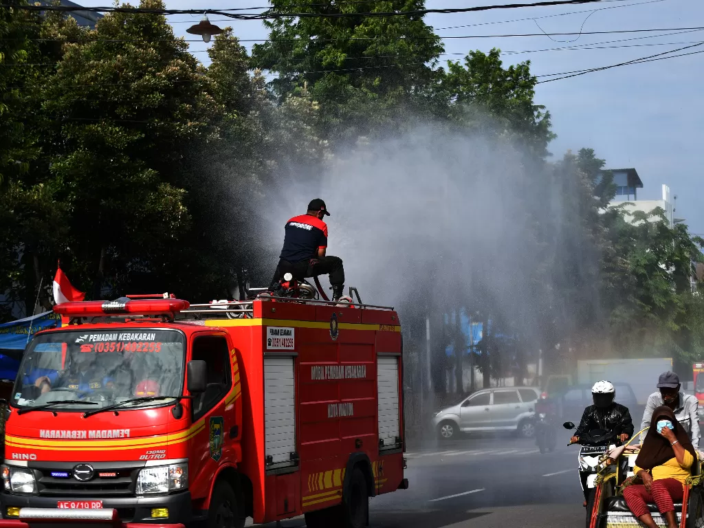 Petugas pemadam kebakaran menyemprotkan cairan disinfektan di fasilitas umum Kota Madiun, Jawa Timur, Rabu (2/2/2022). (Foto/ANTARA FOTO/Siswowidodo/wsj)
