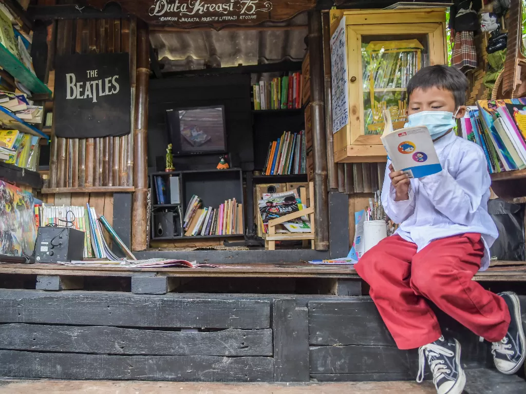 Anak-anak membaca buku di Perpustakaan Bale Buku Meleduk 75, Dukuh, Kramat Jati, Jakarta Timur, Jumat (21/1/2022). (ANTARA/Galih Pradipta)